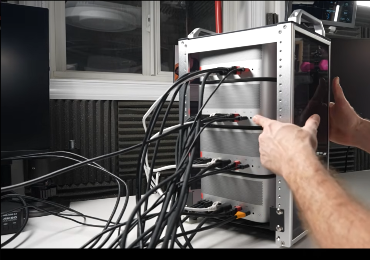 Four Mac Studios stacked in a custom rack, wired together with Thunderbolt 5 cables